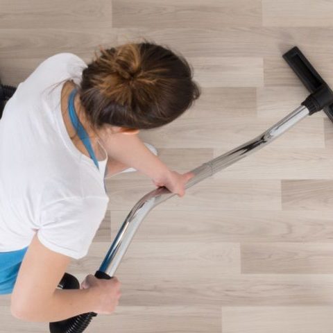 Une technicienne de la société de nettoyage 74 NETT située en Haute-Savoie aspire le sol d'une maison après déménagement